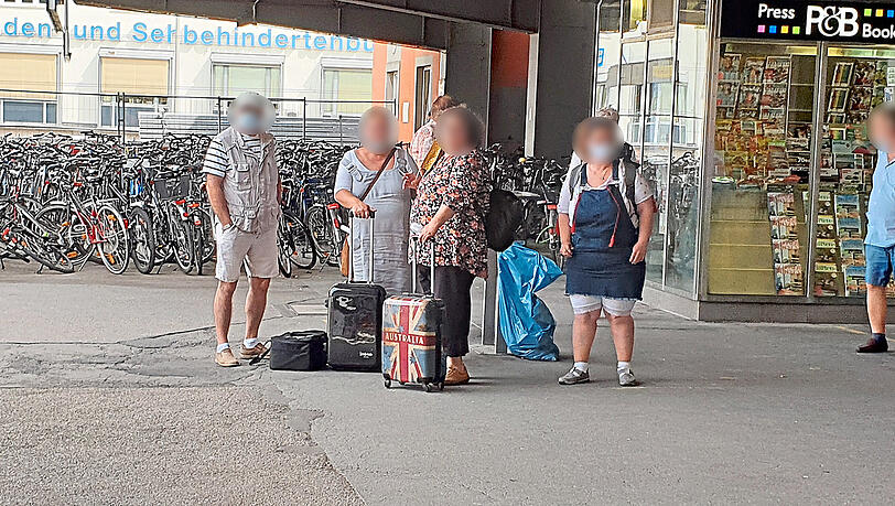 Eine Reisegruppe im Bahnhof: Zwei Damen verzichten auf Masken. Eine Reisegruppe im Bahnhof: Zwei Damen verzichten auf Masken.
