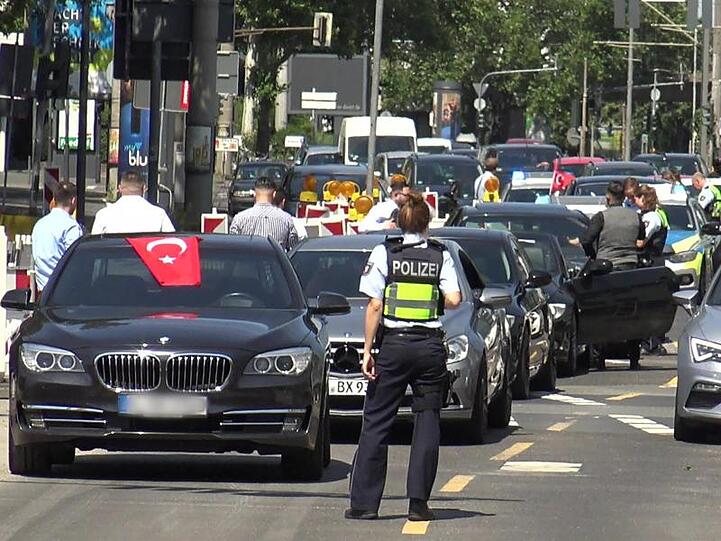 Eine Polizistin steht in Köln vor einem türkischen Hochzeitskorso - einer von dreien, den die Polizei in der Rheinmetropole am Wochenende angehalten hat.