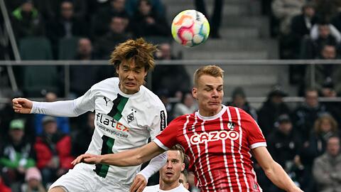 Gladbachs Ko Itakura (l) und Freiburgs Philipp Lienhart im Kopfballduell.