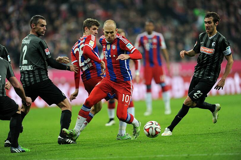 Robben geht mit dem Ball an Pavel Krmas (l.) und Julian Schuster (r.) von Freiburg vorbei