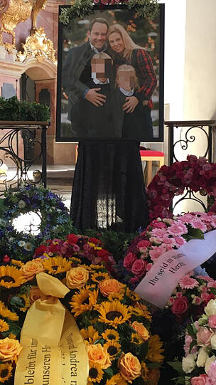 Ein Blumenmeer vor dem Altar und dem Bild der Familie.