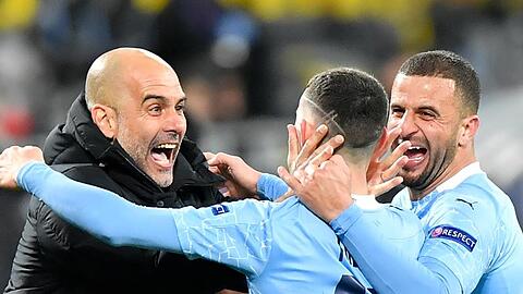 Phil Foden (M) von Manchester jubelt nach seinem Treffer zum 2:1 gegen Dortmund mit Kyle Walker (r) und Trainer Pep Guardiola.