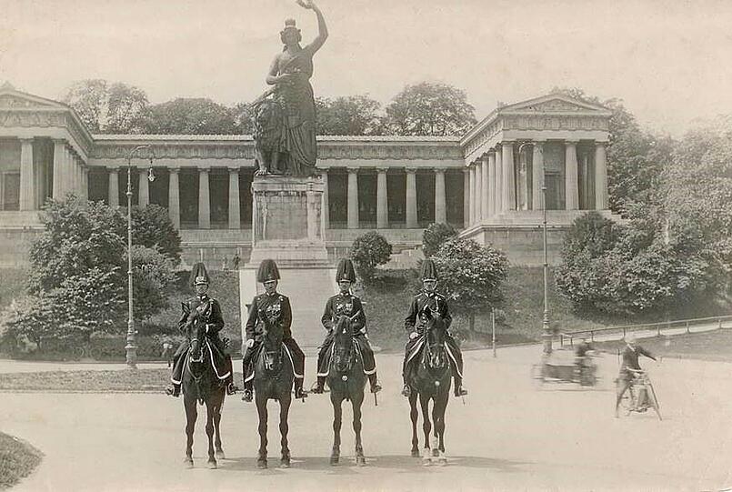 Vier Münchner Polizisten hoch zu Ross im Jahr 1922 zu Füßen der Bavaria.