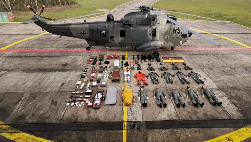 Fünf Seenotretter samt Ausrüstung liegen neben dem Rettungshelikopter SeaKing MK41. Fünf Seenotretter samt Ausrüstung liegen neben dem Rettungshelikopter SeaKing MK41.