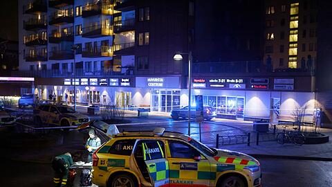 Medizinisches Personal steht in Solna nördlich von Stockholm an der Stelle, an der ein Mann erschossen aufgefunden wurde.