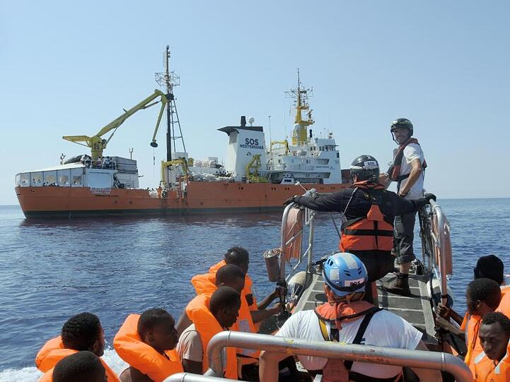 Gerettete Menschen werden an Bord der "Aquarius" gebracht.
