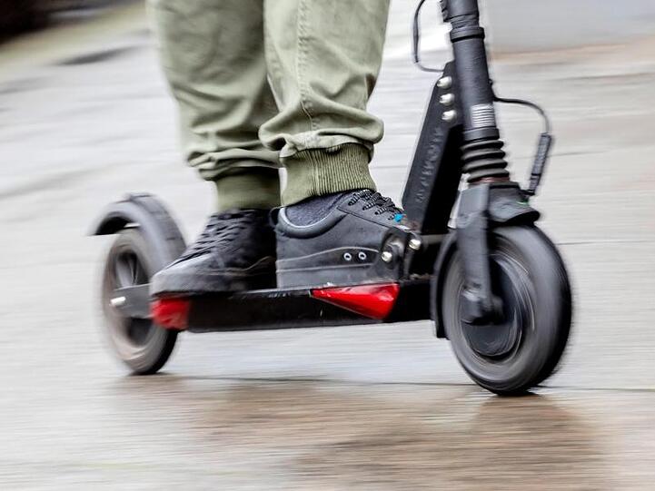 Ein Mann fährt mit einem E-Scooter auf dem Gehweg. Foto: Christoph Soeder/Archivbild