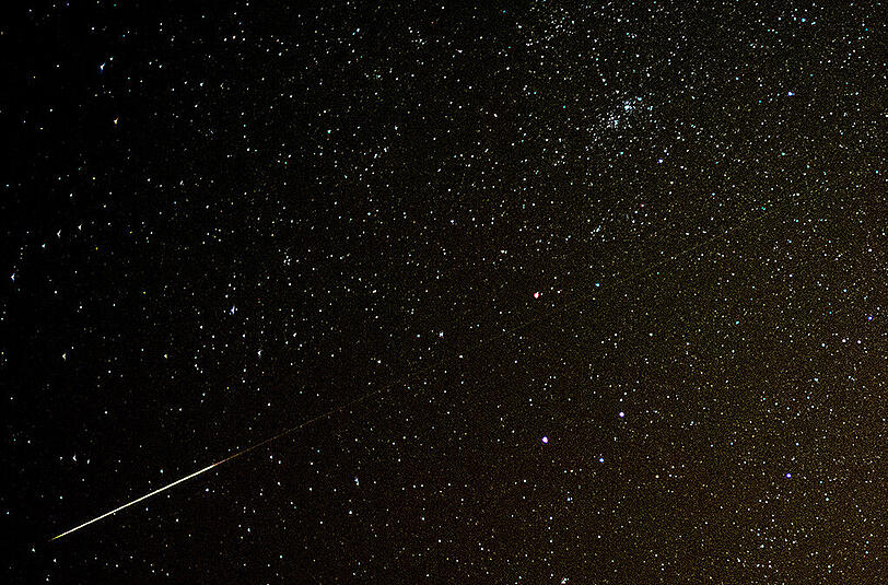 Sternschnuppen der Perseiden am Nachthimmel. Auslöser sind abgelöste Stückchen des Kometen 109P/Swift-Tuttle.