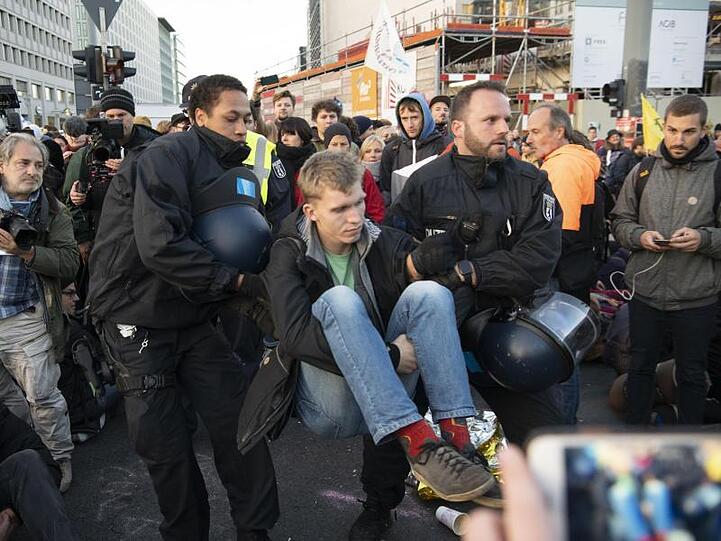 Polizisten tragen einen Aktivisten der Klimabewegung Extinction Rebellion am Potsdamer Platz weg.