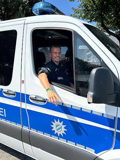 Polizeibeamter Maxi ist seit 7 Uhr im Olympiapark unterwegs und hat von den friedlichen Taylor-Swift-Fans vier Armbänder geschenkt bekommen.