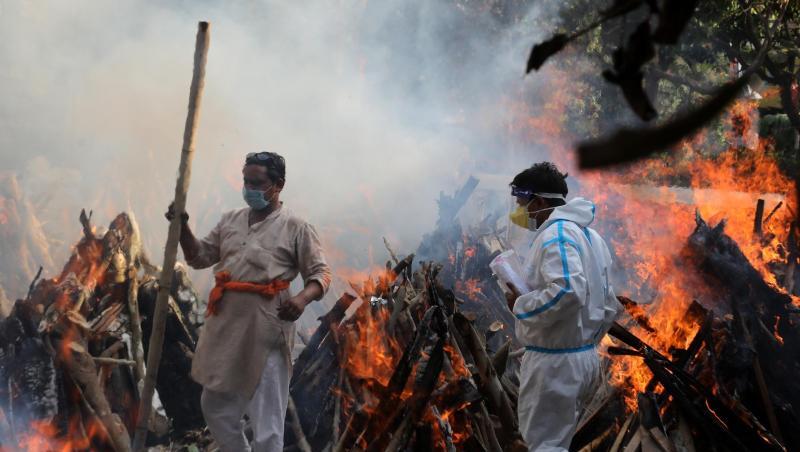 Neu-Delhi: Angehörige neben brennenden Scheiterhaufen von Opfern, die an den Folgen einer Corona-Infektion gestorben sind.