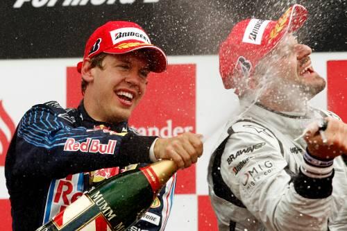 Schampus-Dusche nach  dem Sieg in Silverstone: Sebastian Vettel  (l.) mit   Rubens Barrichello.