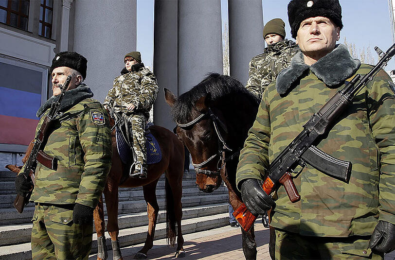Bewaffnete, prorussishe Separatisten stehen in Donezk. Bald soll ein zu neuen Gesprächen zwischen den Separatisten und der ukrainischen Regierung kommen.