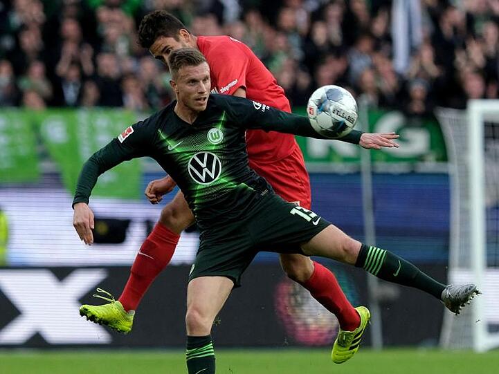 Wolfsburgs Yannick Gerhardt und Augsburgs Rani Khedira (l-r.) im Zweikampf um den Ball. Foto: Peter Steffen/dpa