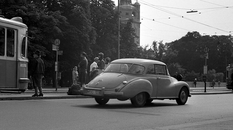 Schottische Touristen und ein alter DKW an der Tramhaltestelle Deutsches Museum &ndash; hinten ist das Müllersche Volksbad zu sehen.
