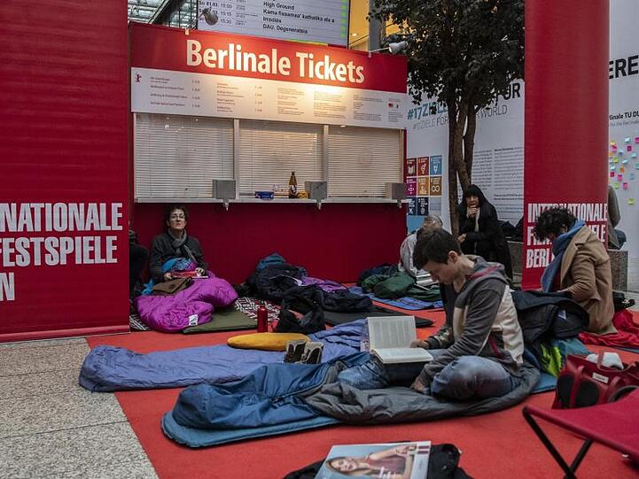 Film-Liebhaber in den Potsdamer Platz Arkaden vor einem noch geschlossenen Kassenhäuschen.