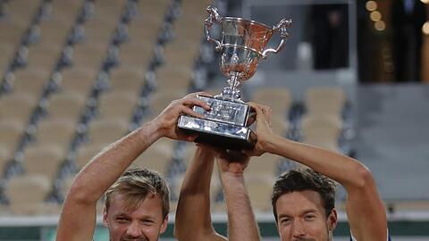Kevin Krawietz (l) und Andreas Mies feiern mit der Trophäe den Finalsieg.