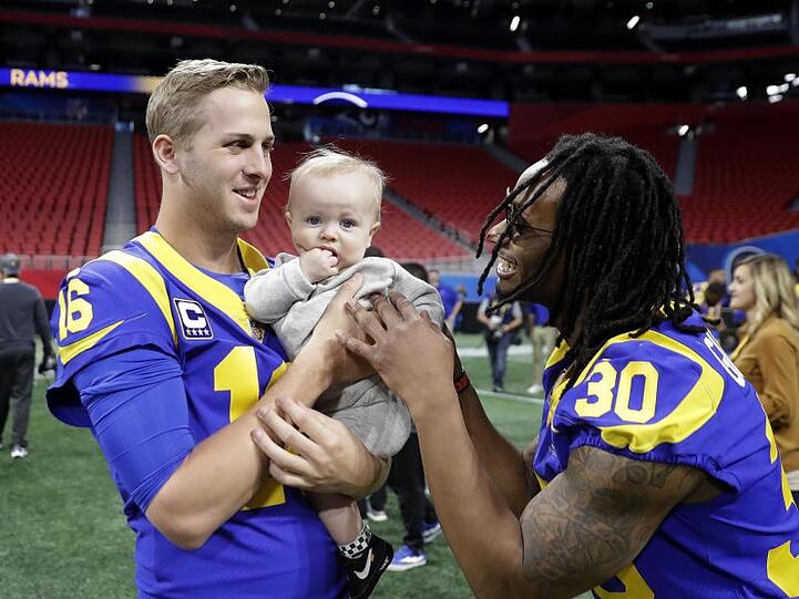 Jared Goff (l) und Todd Gurley (r) spielen mit Cooper Kupp Jr. bei der Platzbesichtigung im Mercedes Benz Stadion. Cooper ist der Sohn von Wide Receiver Cooper Kupp.