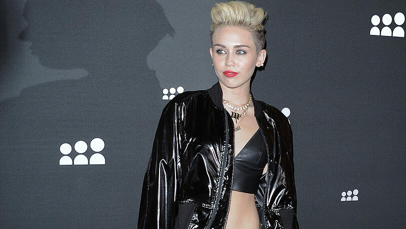 Miley Cyrus stylt ein Lack-Blouson zum Crop Top Miley Cyrus stylt ein Lack-Blouson zum Crop Top