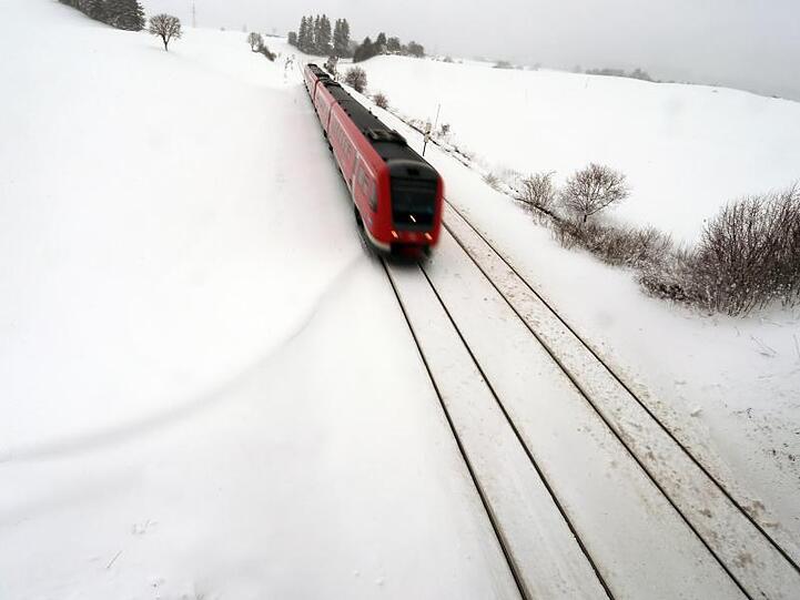 Ein Regionalexpress fährt durch die schneebedeckte Landschaft. Foto: Karl-Josef Hildenbrand/Archiv