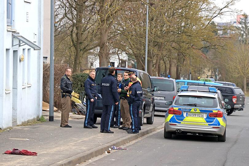 Polizisten stehen neben den Einsatzwägen vor einer Obdachlosenunterkunft. In der Unterkunft hat die Polizei Chemikalien entdeckt, aus denen Sprengstoff hergestellt werden kann.