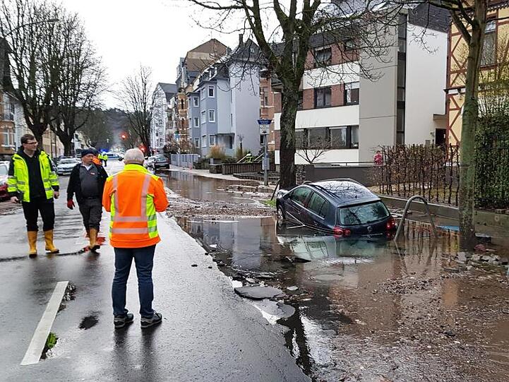 Ein Auto ist nach einem Wasserrohrbruch in der Mainzer Straße in Koblenz im Schlamm versunken.