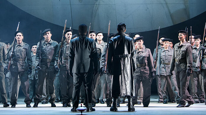 Der Krieg mag vorbei sein, doch er wirft seine Schatten über Gegenwart. Dabei haben sich die Soldatinnen und Soldaten zum grandiosen Chor des Gärtnerplatztheaters vewandelt.