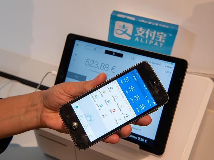 In einem Showroom von Wirecard wird beispielhaft das kontaktlose Bezahlen mit ALIPAY vorgeführt. Foto: Peter Kneffel/Archiv