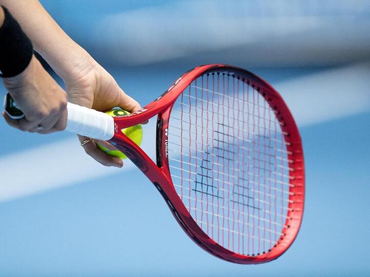 Ein Tennisschläger wird zum Aufschlag benutzt. Foto: Julian Stratenschulte/dpa/Archivbild