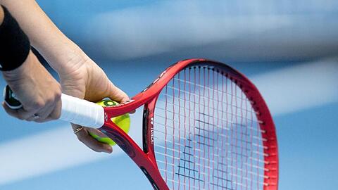 Ein Tennisschläger wird zum Aufschlag benutzt. Foto: Julian Stratenschulte/dpa/Archivbild
