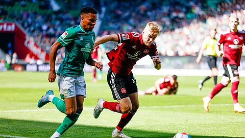 Bremens Felix Agu (l) und Nürnbergs Tim Handwerker kämpfen um den Ball.
