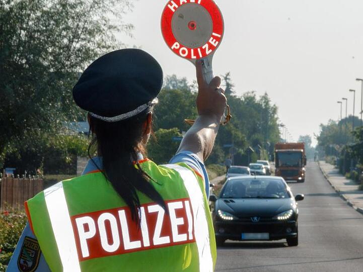 Eine Polizistin stoppt einen Fahrer auf der Straße. Foto: Peter Förster/Archiv