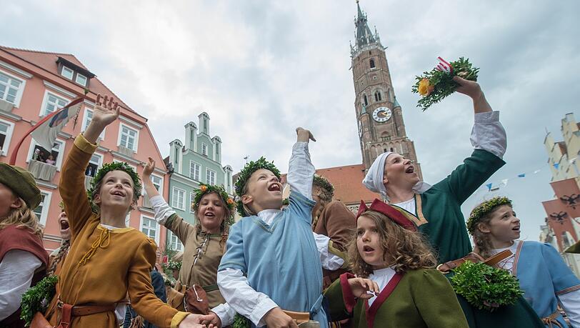 Frauen und Kinder in historischer Kleidung winken am 2017 in Landshut während der Landshuter Hochzeit.