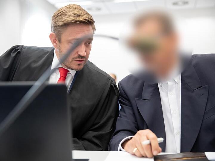 Ein Anwalt (l) unterhält sich mit dem wegen Totschlags angeklagten Mann im Landgericht Bamberg zum Prozessbeginn. Foto: D. Karmann/Archiv
