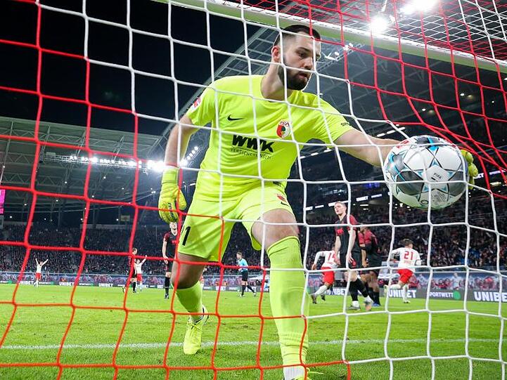 Augsburgs Torwart Tomas Koubek fischt den Ball aus dem Netz. Foto: Jan Woitas/dpa-Zentralbild/dpa/Archivbild