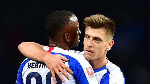 Neuzugang Krzysztof Piatek (r) und Dodi Lukebakio von Hertha umarmen sich nach Spielende.