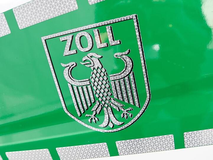 Das Zoll-Logo ist auf einem Einsatzfahrzeug des Zolls zu sehen. Foto: Christophe Gateau/Archivbild