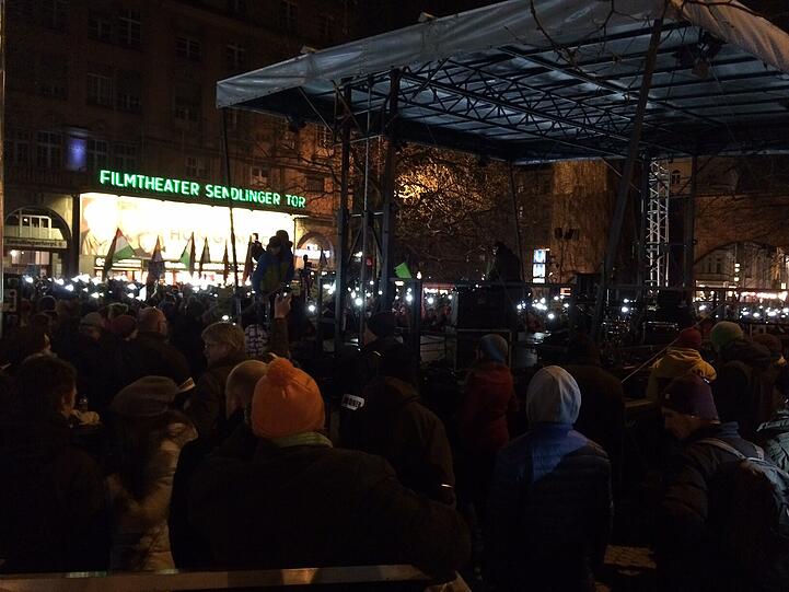 Die Gegendemonstranten machen ihre Handy-Lichter an.