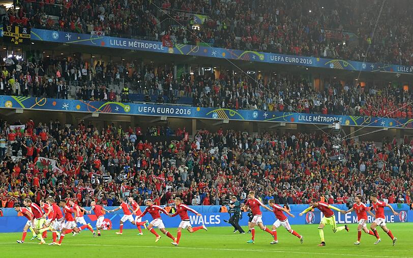 So schön können wohl nur Überraschungs-Sieger jubeln. Die Waliser feiern ihren unerwarteten Sieg gegen Titelanwärter Belgien.
