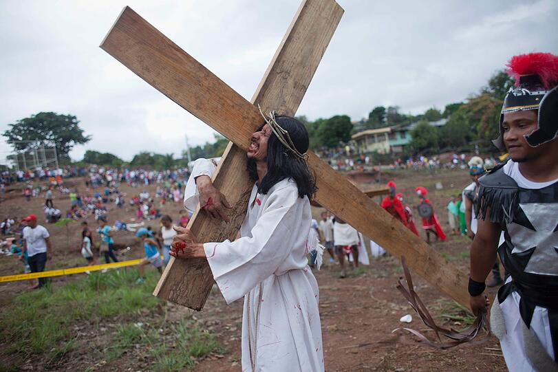 Ebenfalls in Panama trägt ein Mann in der Gestalt Jesu das Kreuz.