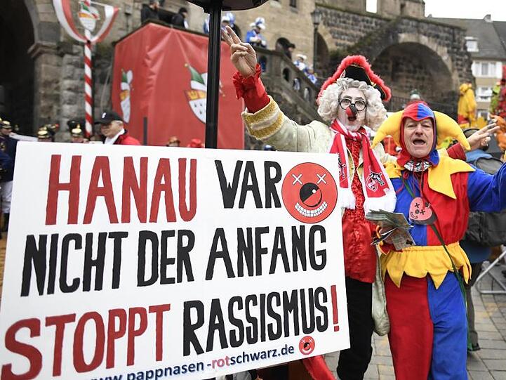 Karnevalisten erinnern vor Beginn des Rosenmontagszuges an die schrecklichen Ereignisse in Hanau.