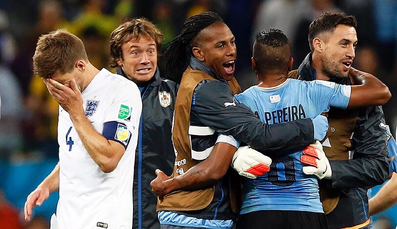 Während die Spieler von Uruguay feiern, ist Englands Kapitän Steven Gerrard geknickt und den Tränen nahe.