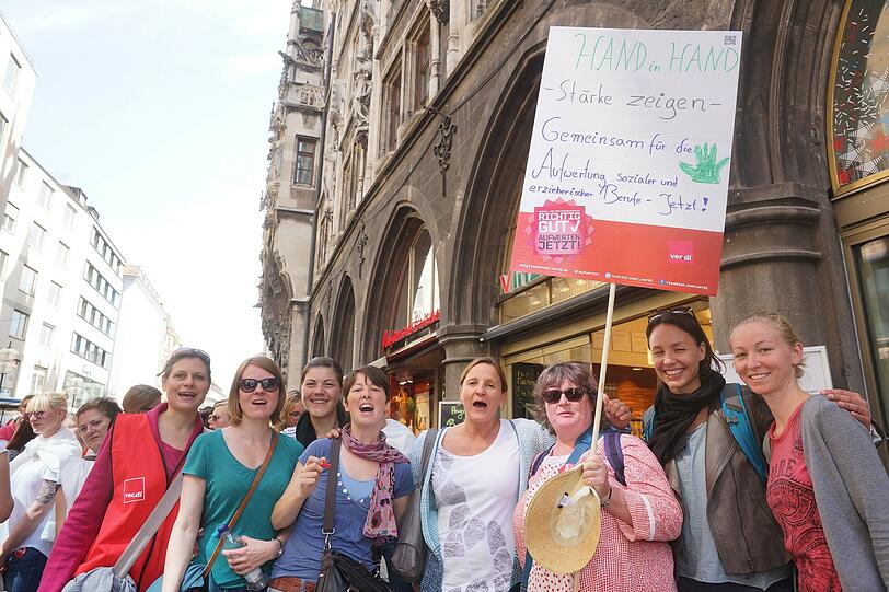 Erzieherinnen, Mütter und Sozialarbeiterinnen und Unterstützer bei Menschenkette am Marienplatz in München.