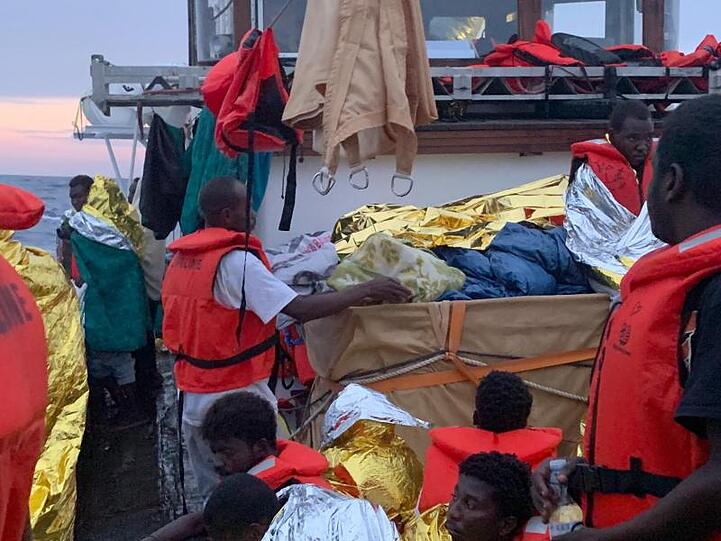 Nach einem Gewitter mit schweren Regenfällen schützen sich die rund 100 Migranten an Deck der "Eleonore" mit Rettungsdecken.