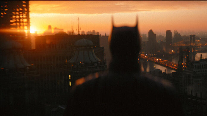 Die Silhouette des Superhelden vor Gotham City bei Sonnenuntergang - Beginn der aktiven Phase von Batman.