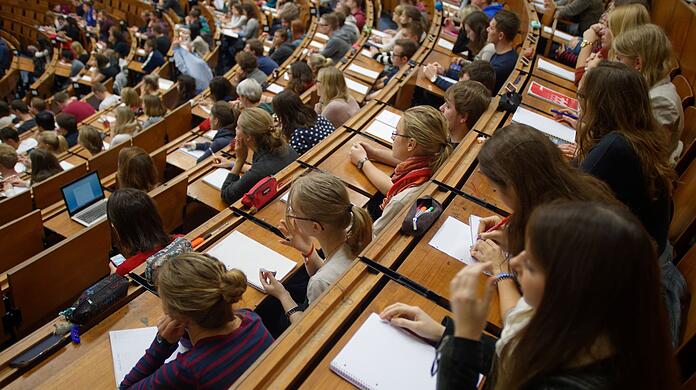 Studentinnen und Studenten verfolgen eine Vorlesung.