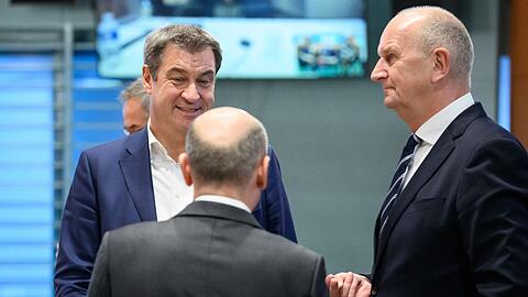 Markus Söder (l, CSU), Ministerpräsident von Bayern, Bundeskanzler Olaf Scholz (SPD) und Dietmar Woidke (r, SPD), Ministerpräsident von Brandenburg, unterhalten sich.