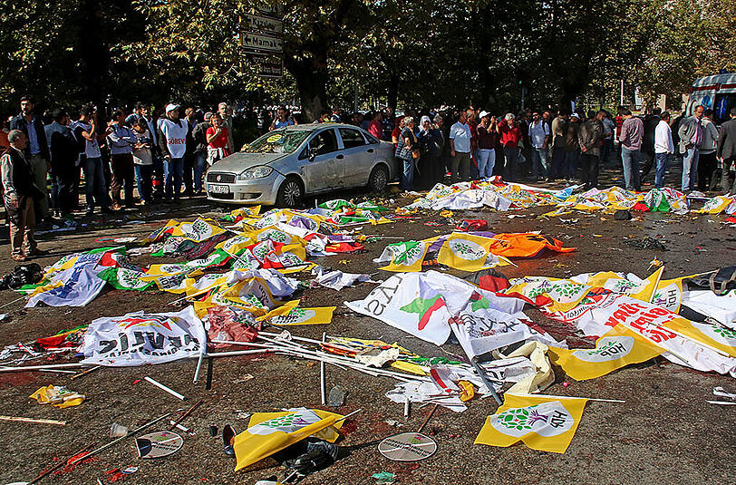 Die Demo-Teilnehmer bedecken die Opfer mit Flaggen und Plakten. Das türkische Innenministerium gab bekannt, dass 30 Menschen bei den Explosionen im Zentrum Ankaras gestorben sind.