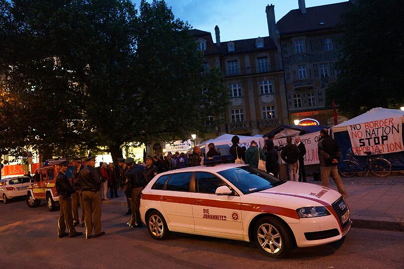 Polizisten und Notärzte stehen um das Camp am Rindermarkt. Seit Dienstag trinken die Protestierenden nichts mehr.