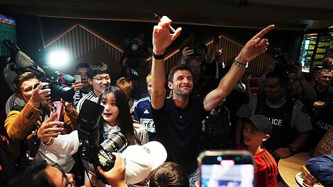 Thomas Müller feiert mit Fans der Vancouver Whitecaps bei seiner Ankunft am Flughafen.